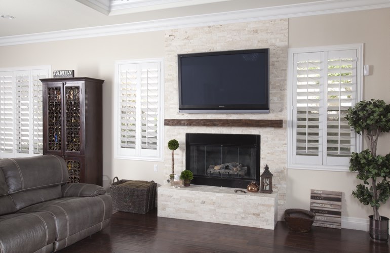 White plantation shutters in a Phoenix living room with solid hardwood floors.